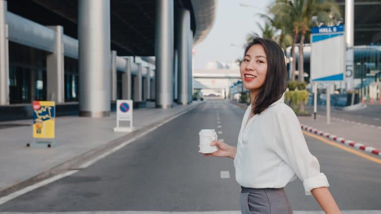 airport transfer singapore: An asian woman with a cup of coffee at the airport